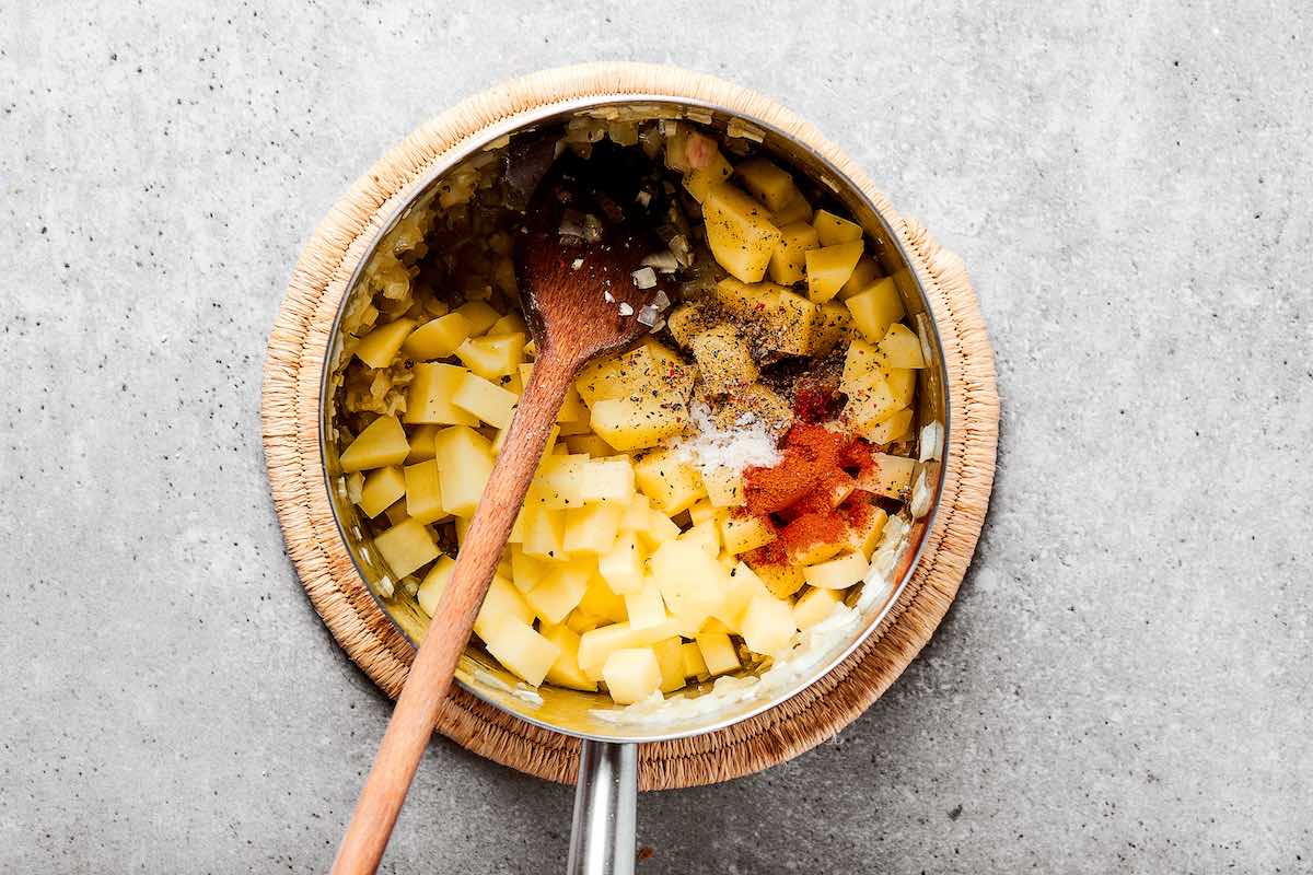 potatoes, onions, garlic, and seasonings in pot.