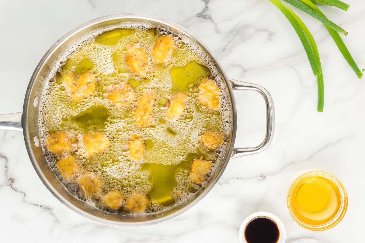 chicken pieces deep frying in oil.