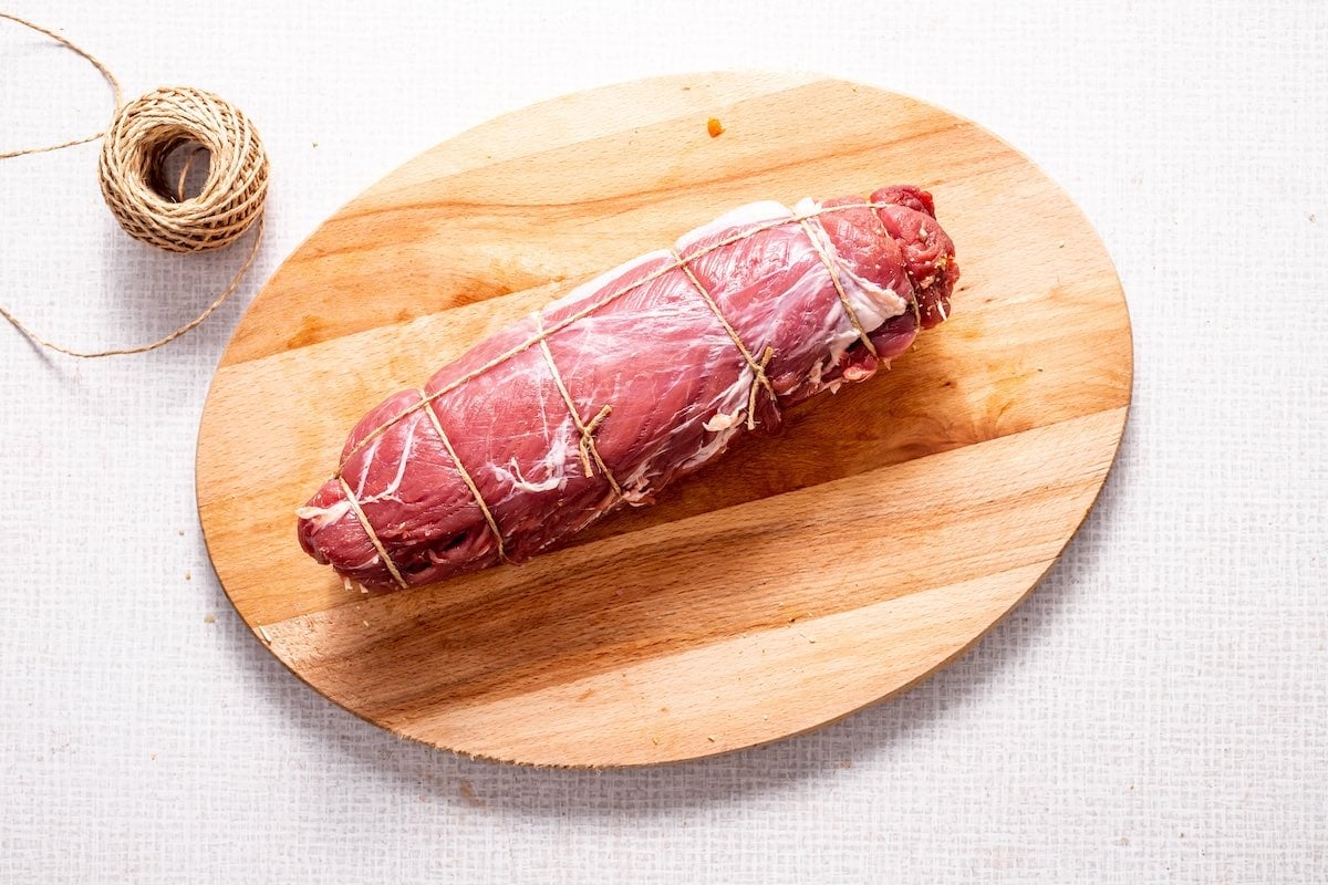 raw stuffed pork loin wrapped with twine.