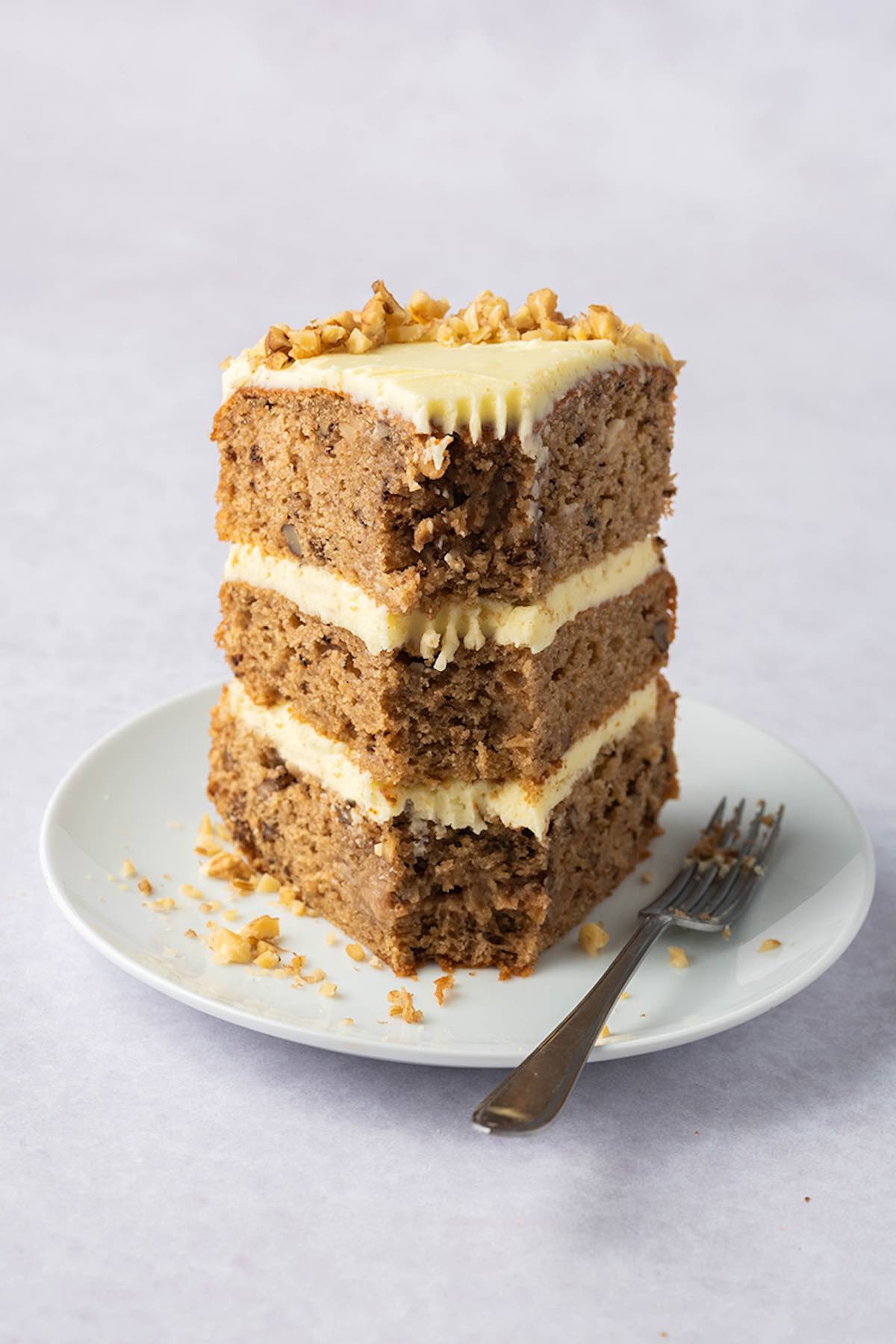 frosted walnut cake with crushed walnuts on top.