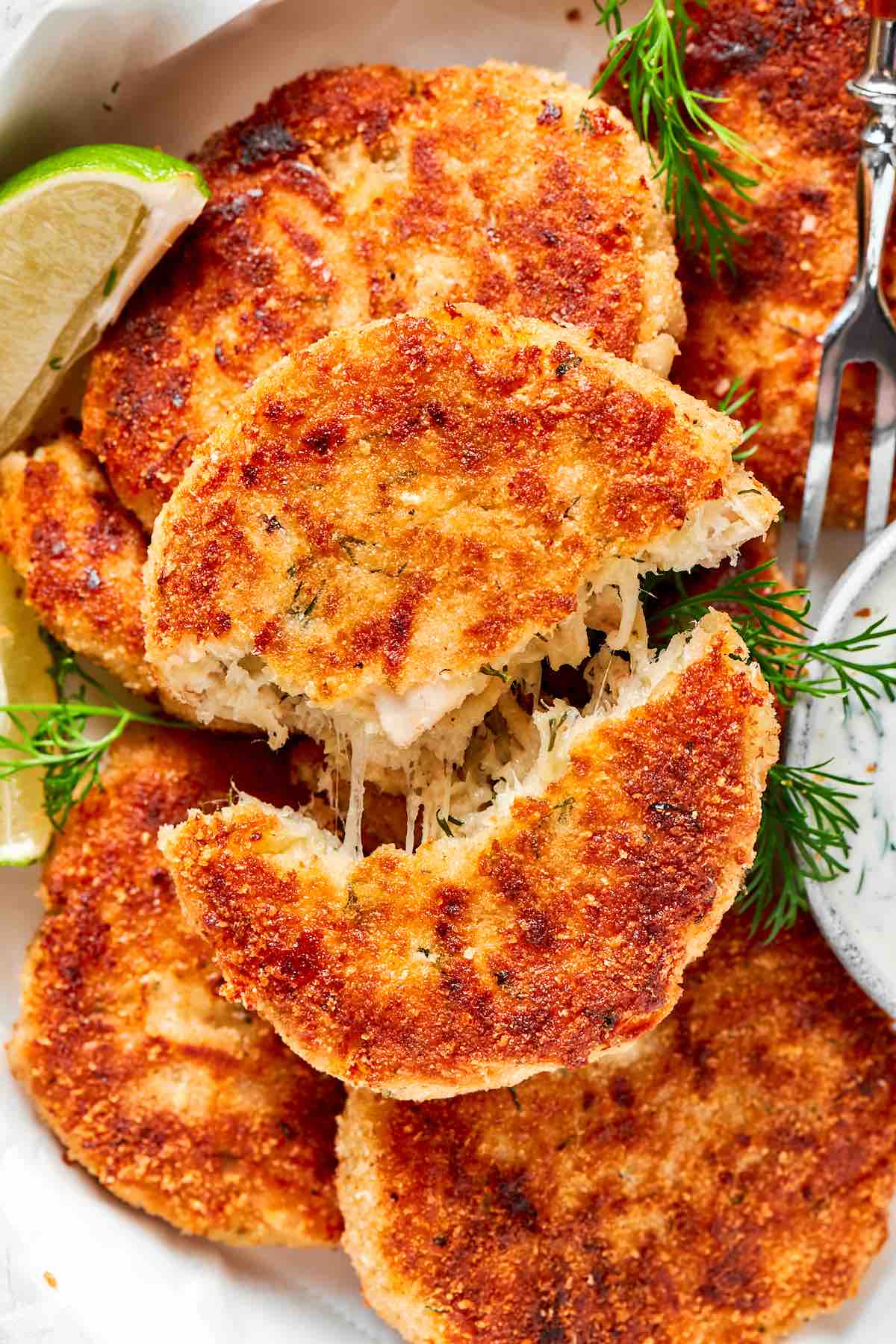 cheesy chicken patties on a plate with fresh limes.