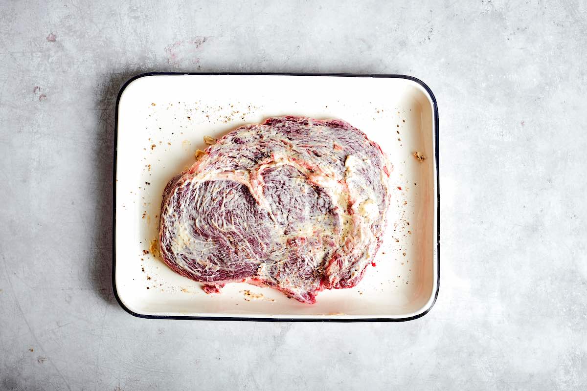 butter rubbed raw ribeye steak.