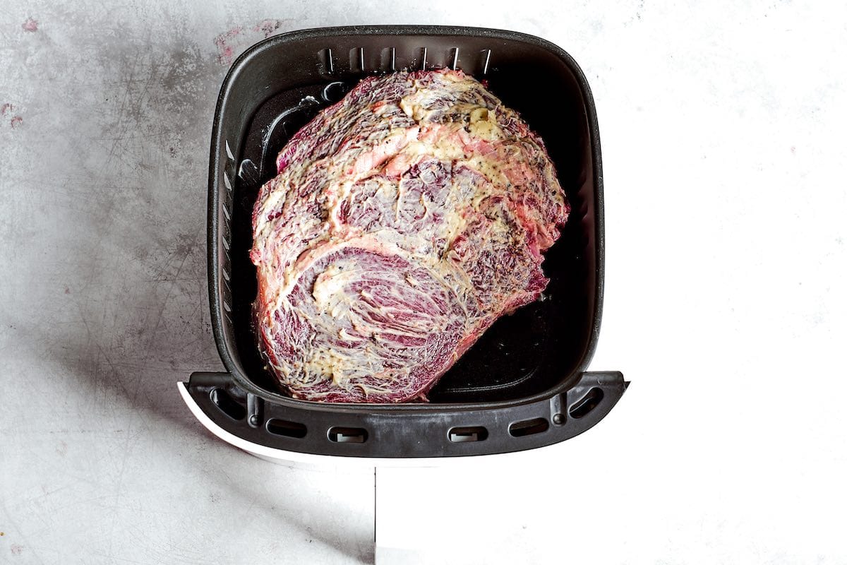 raw seasoned ribeye steak in the air fryer.