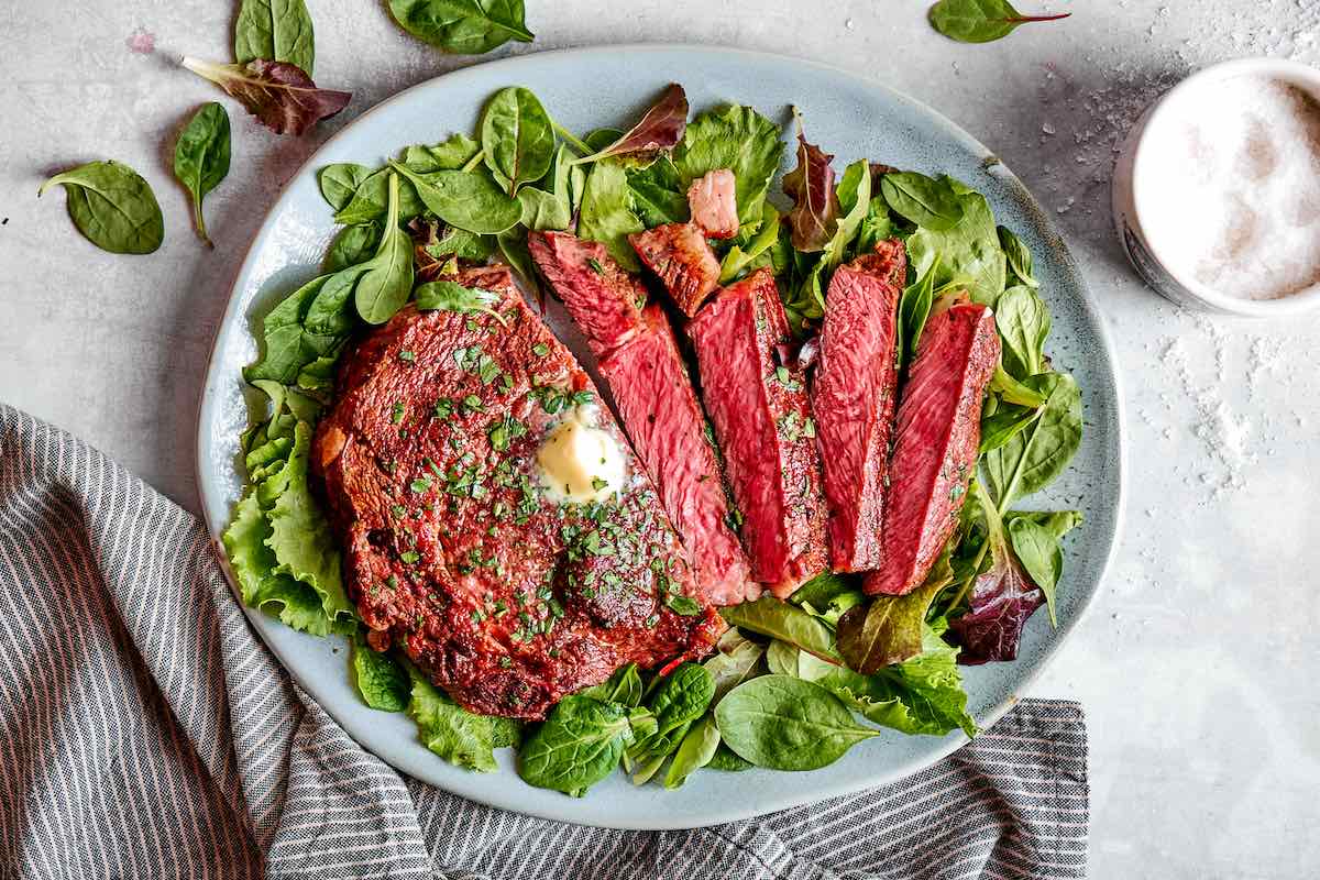 air fried ribeye steak on a bed of lettuce.