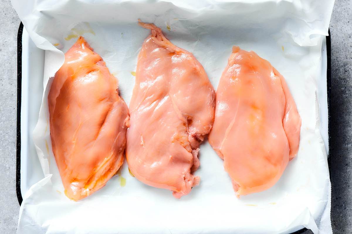 flatted and oiled raw chicken breasts.