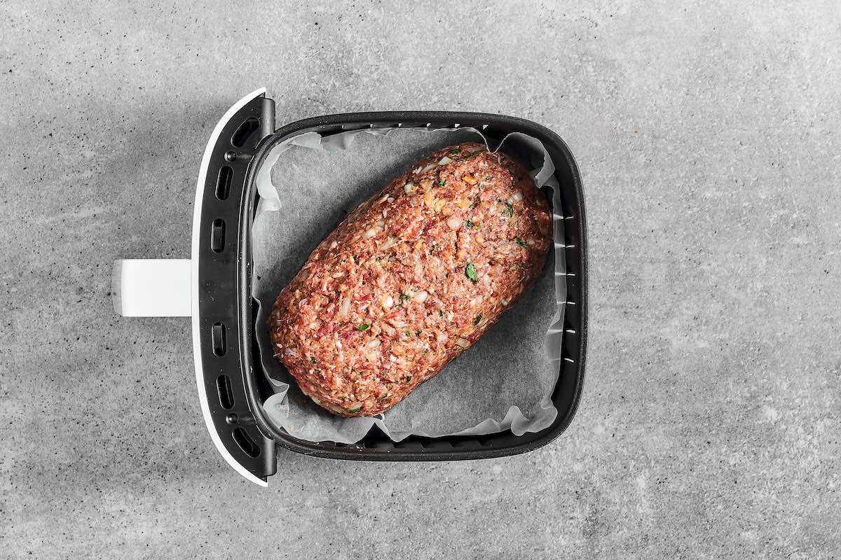 shaped uncooked meatloaf in the air fryer.