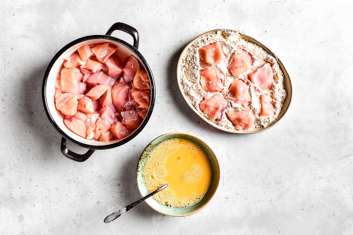 raw chicken cubes covered in flour mixture.