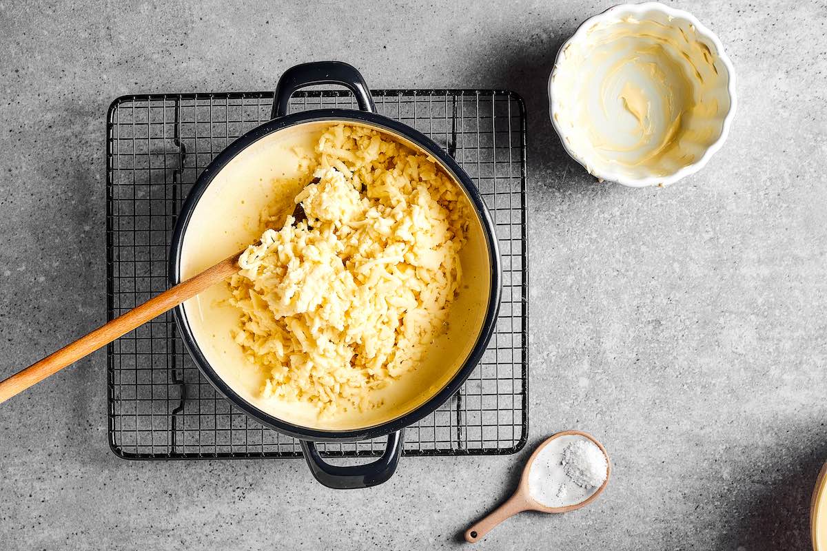 adding shredded cheese to a skillet.