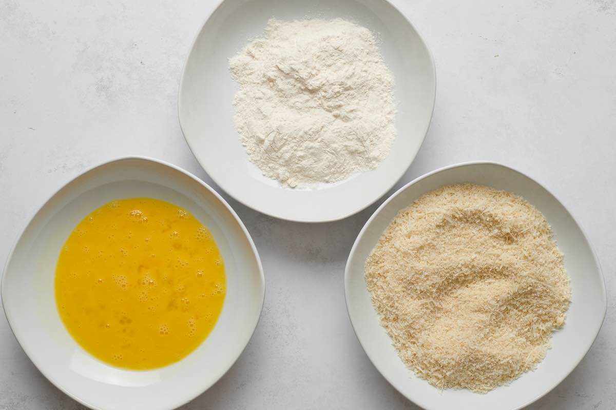 bowl of eggs, flour, and bread crumbs.