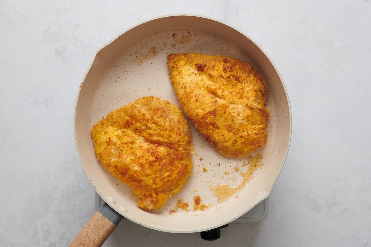 frying breaded chicken in a skillet.