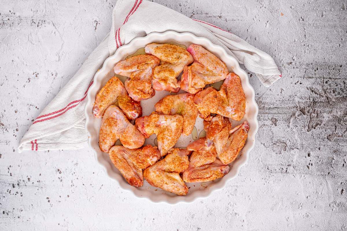 seasoned raw chicken wings in a baking dish.