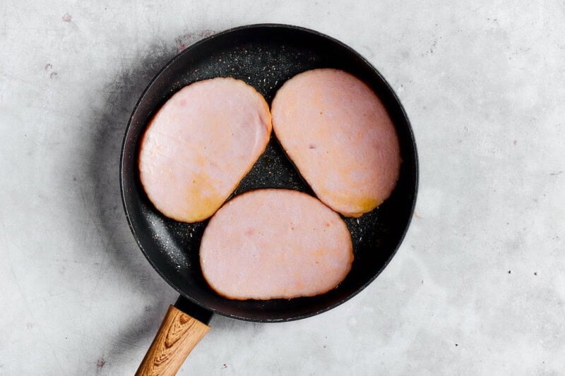 ham steaks pan frying in a skillet.