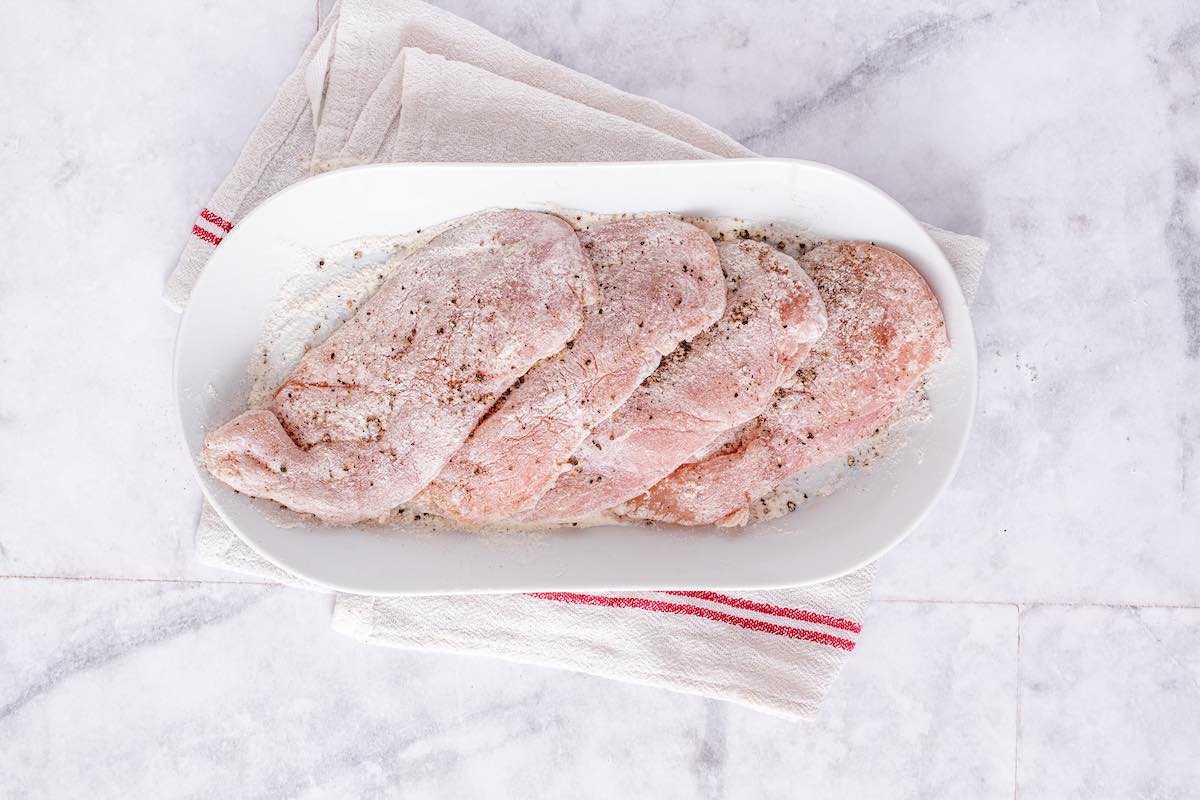 raw chicken breast fillets with flour.