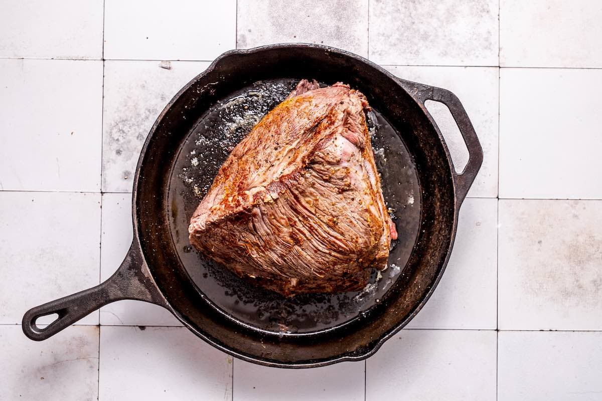 seared chuck roast in a skillet.