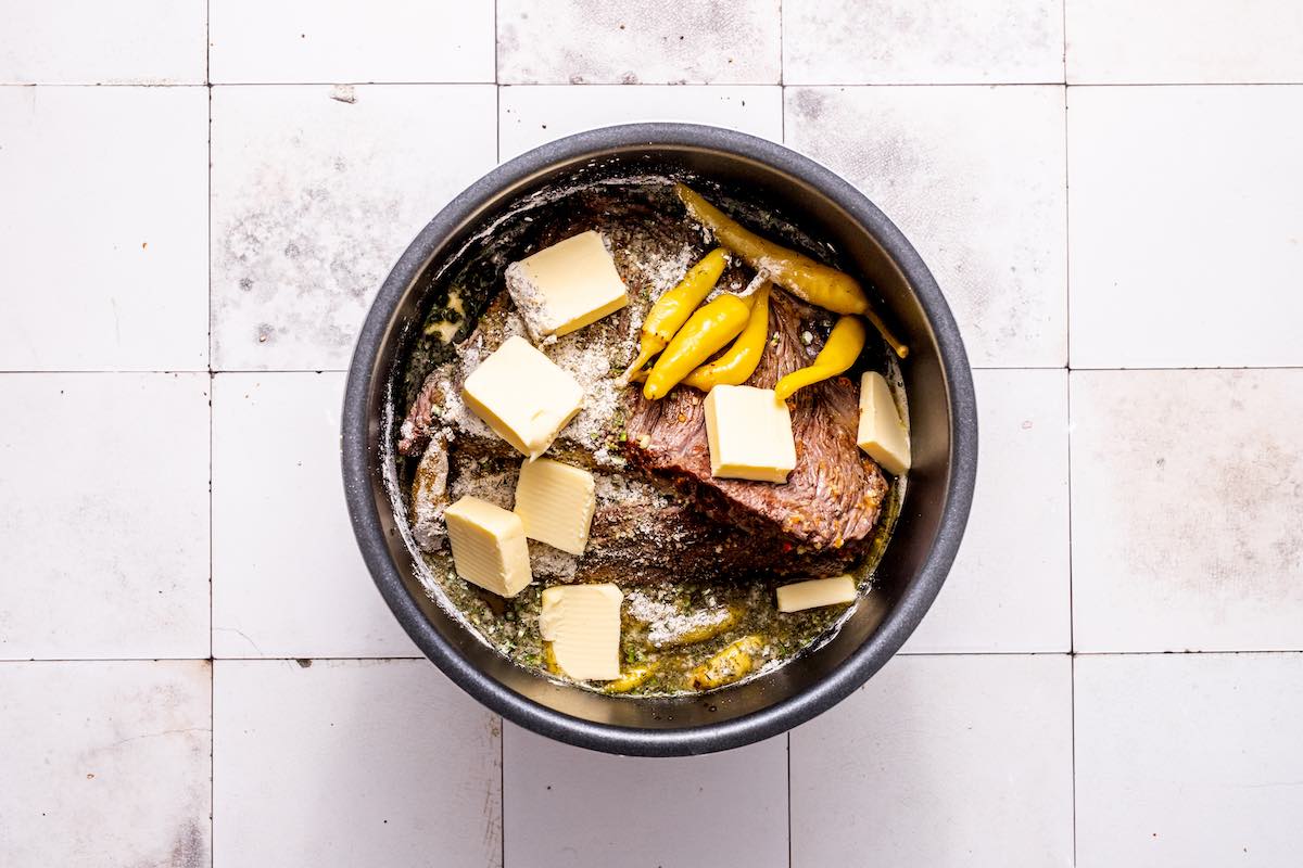 seared meat, seasonings, and broth in a slow cooker.