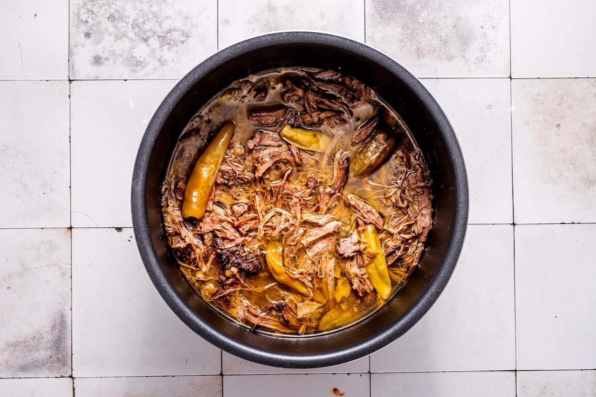 shredded meat and broth in pot.