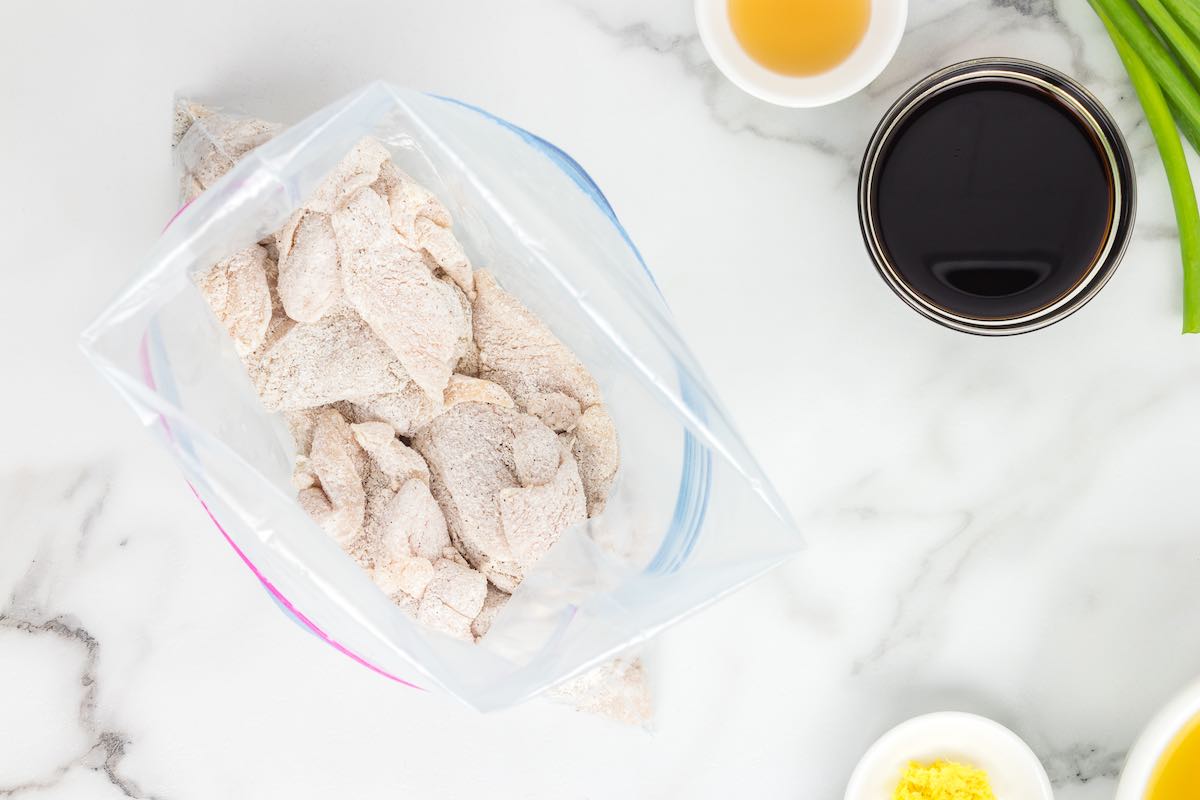 raw chicken slices covered in flour.