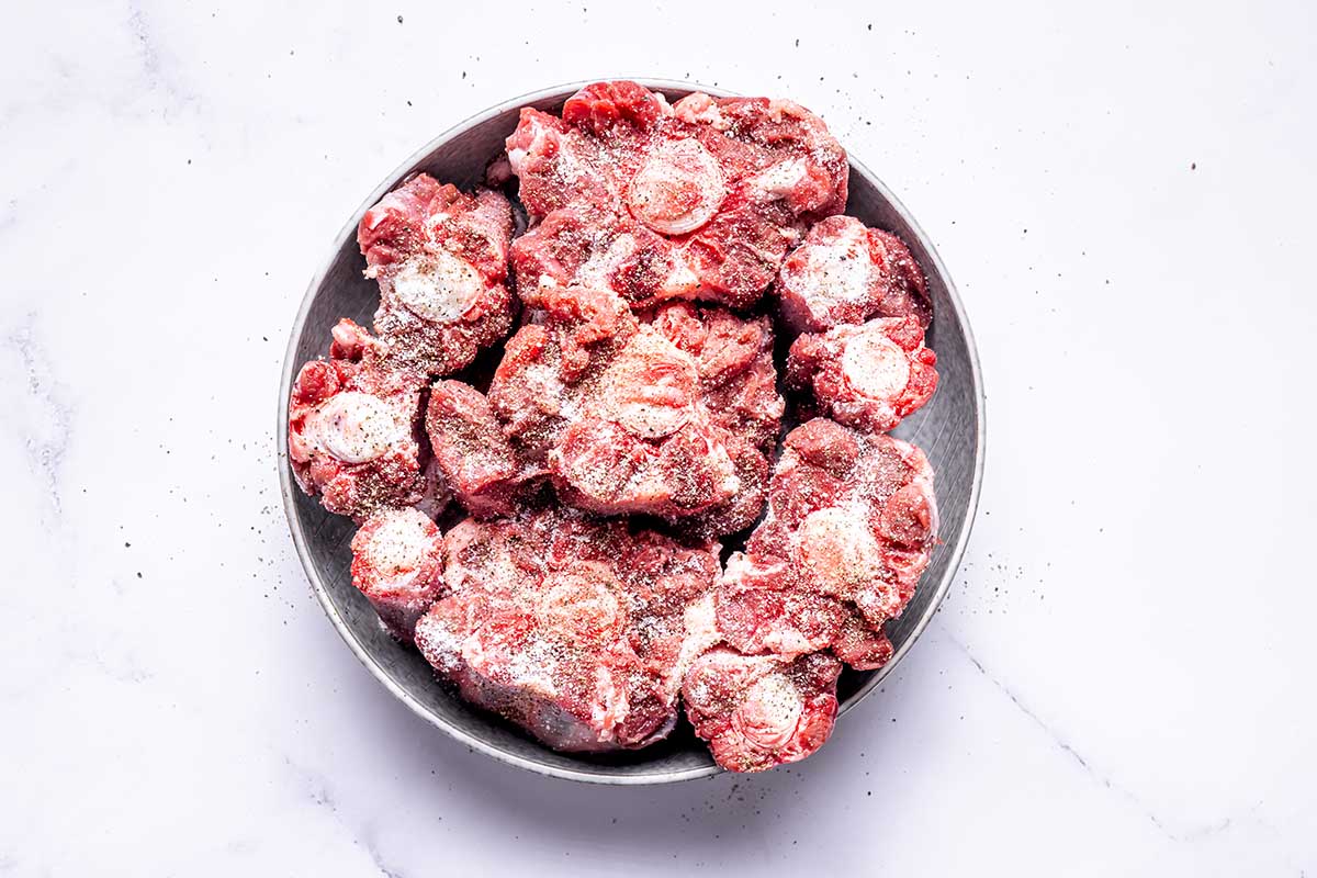 seasoned raw oxtails on a plate.