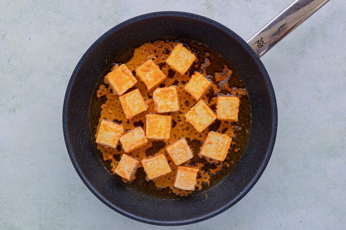 pan frying paneer chucks in a skillet.