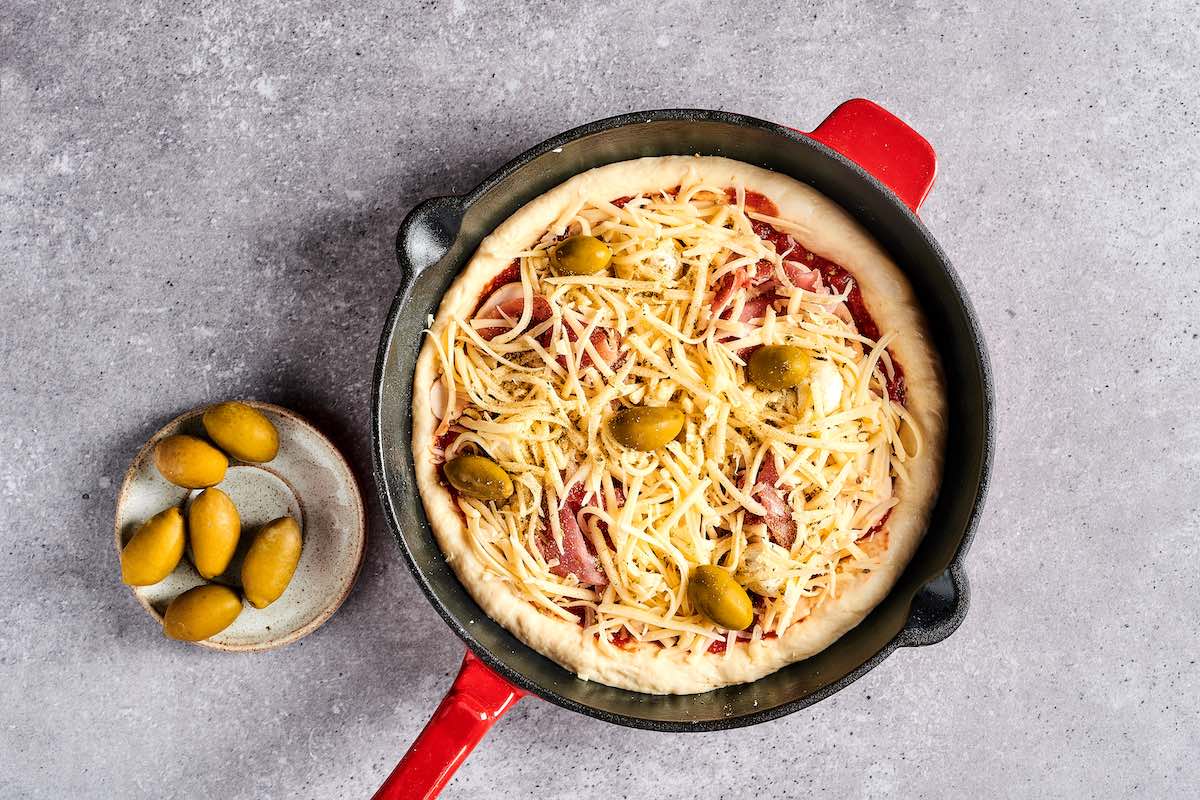 assembled unbaked pizza in a cast iron.