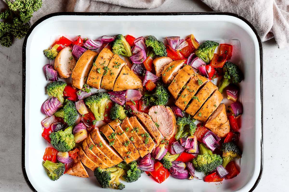 baked chicken and vegetables on a sheet pan.