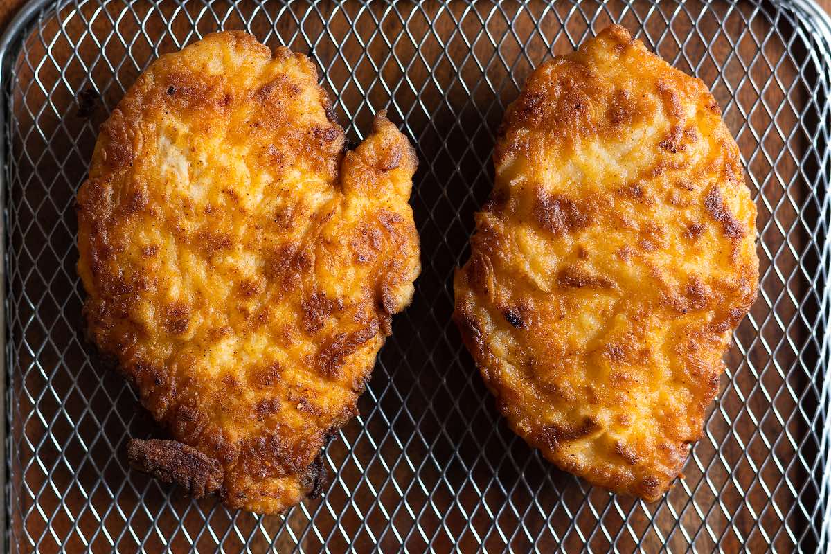 crispy fried chicken breast on a cooling rack.