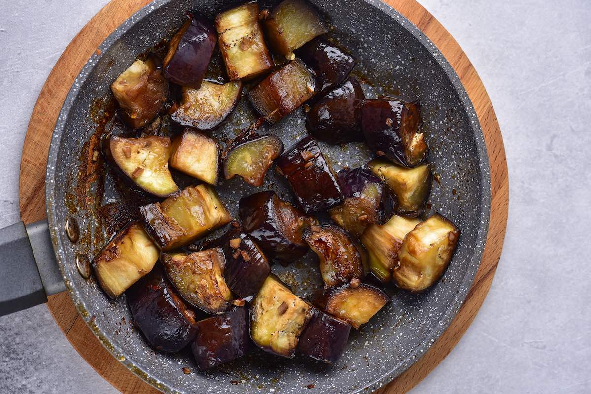 eggplant sautéing in a skillet.