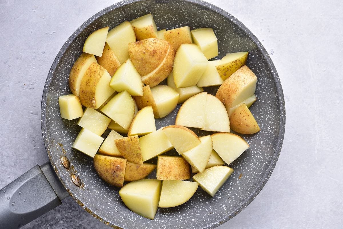 raw potatoes in a skillet.