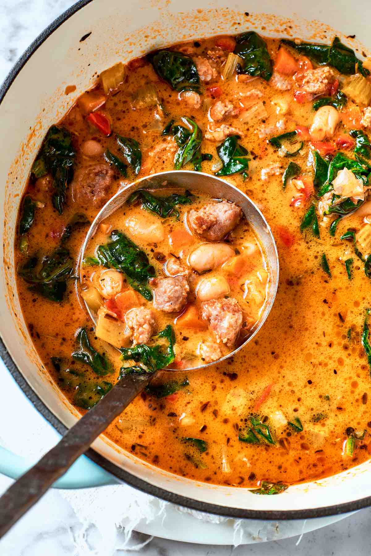 Italian sausage soup in a soup pot.