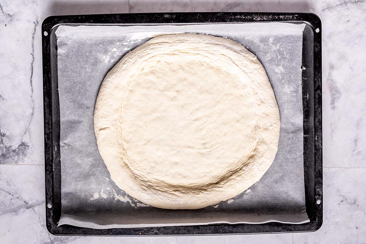 pizza dough on a baking tray.