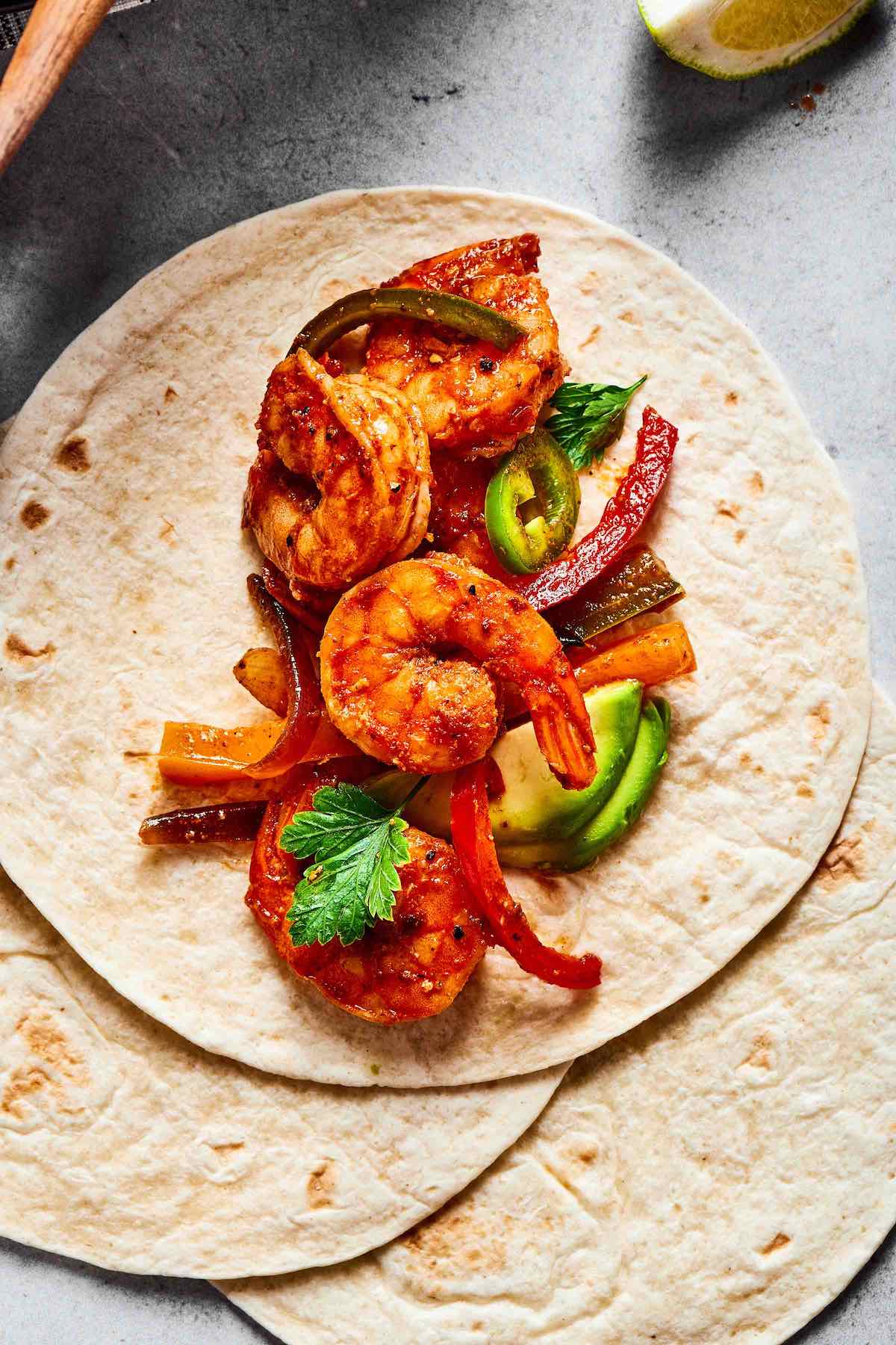 shrimp fajitas over tortillas.