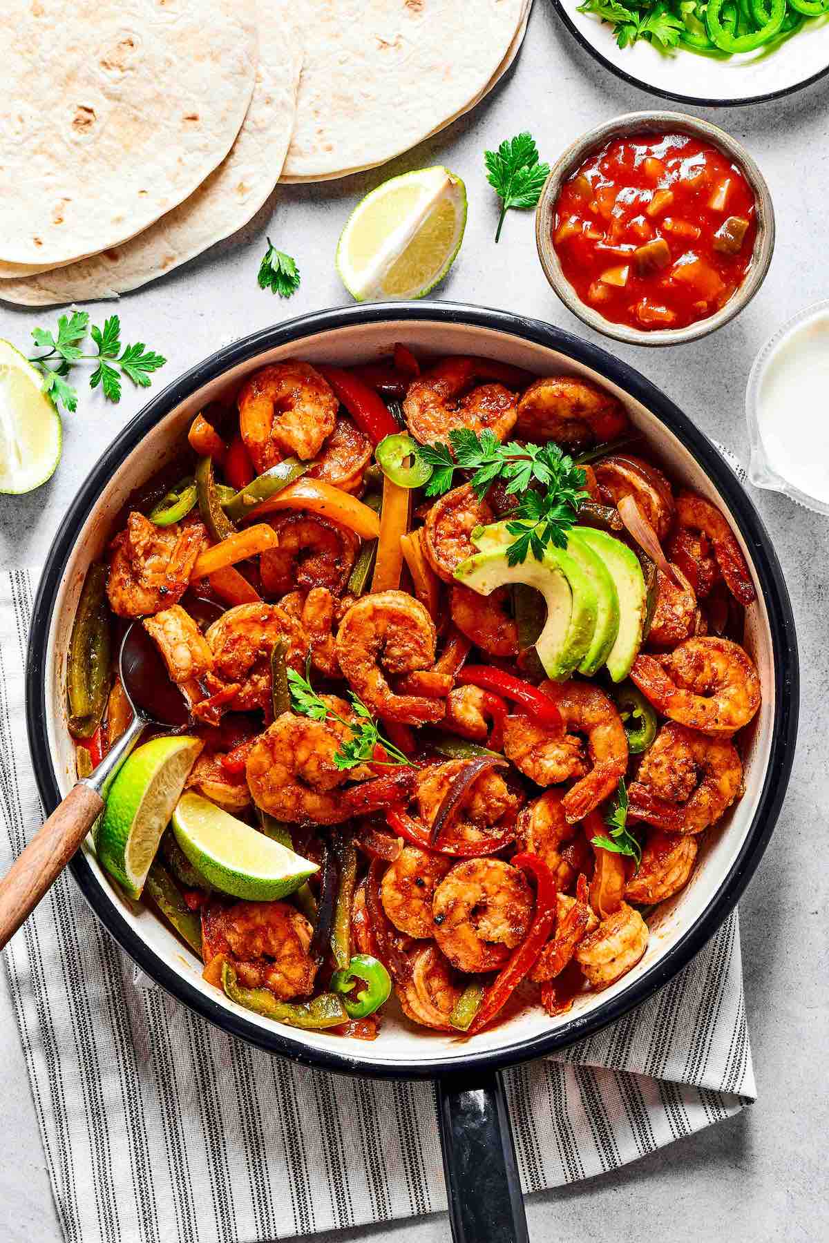 homemade shrimp fajitas with sliced avocado and lime.