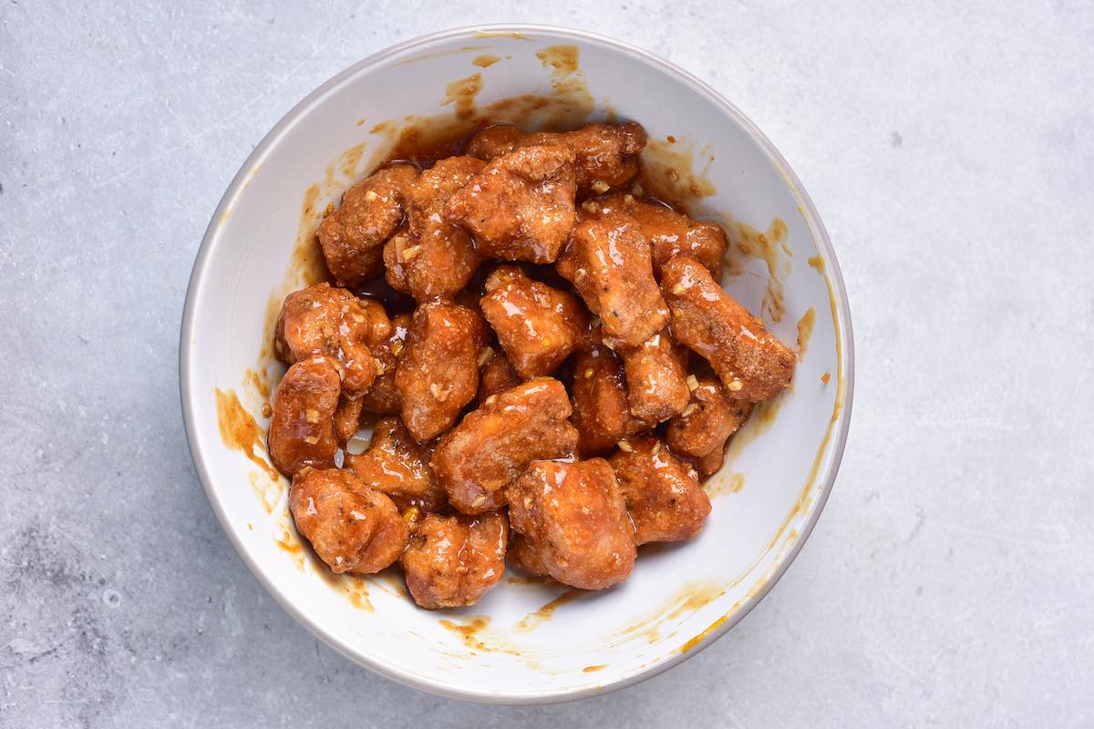 breaded chicken covered in orange sauce.