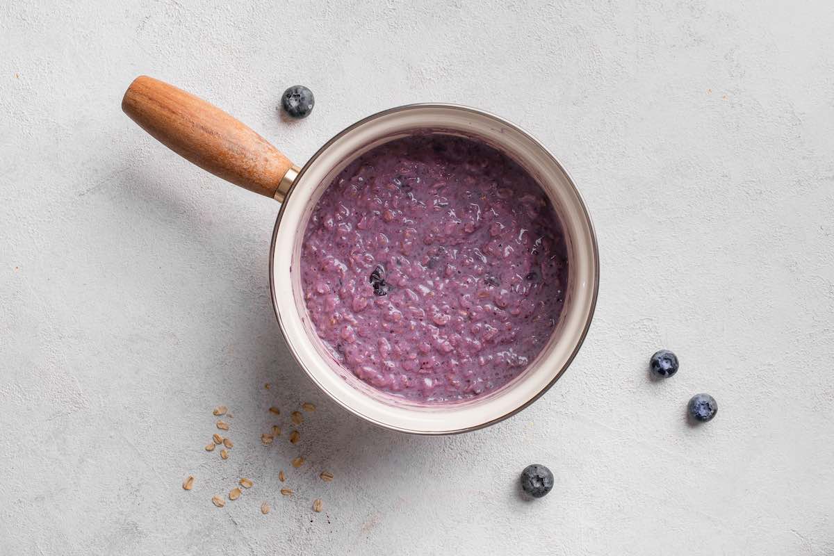 cooked blueberry oatmeal in a saucepan.