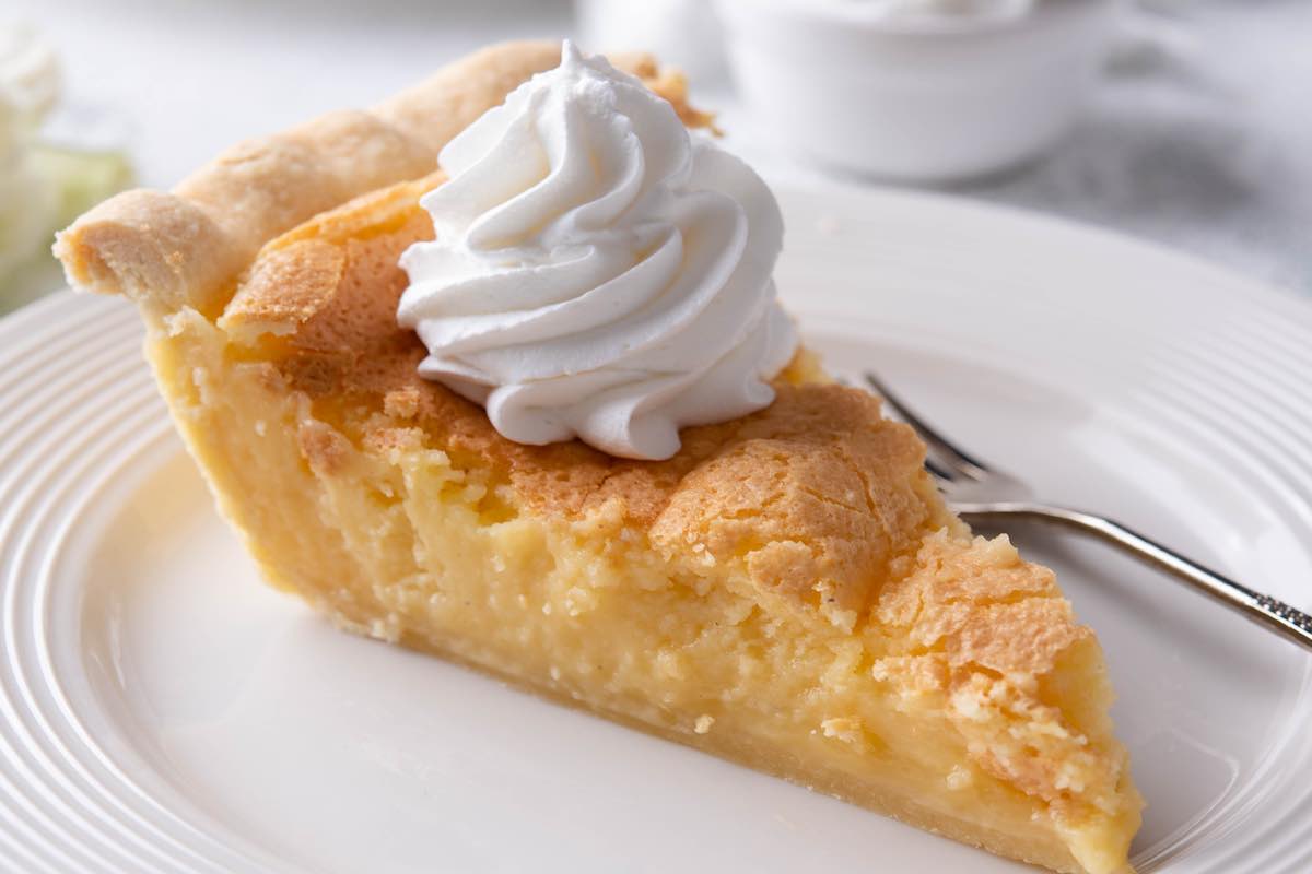 baked buttermilk pie with whipped cream on top.