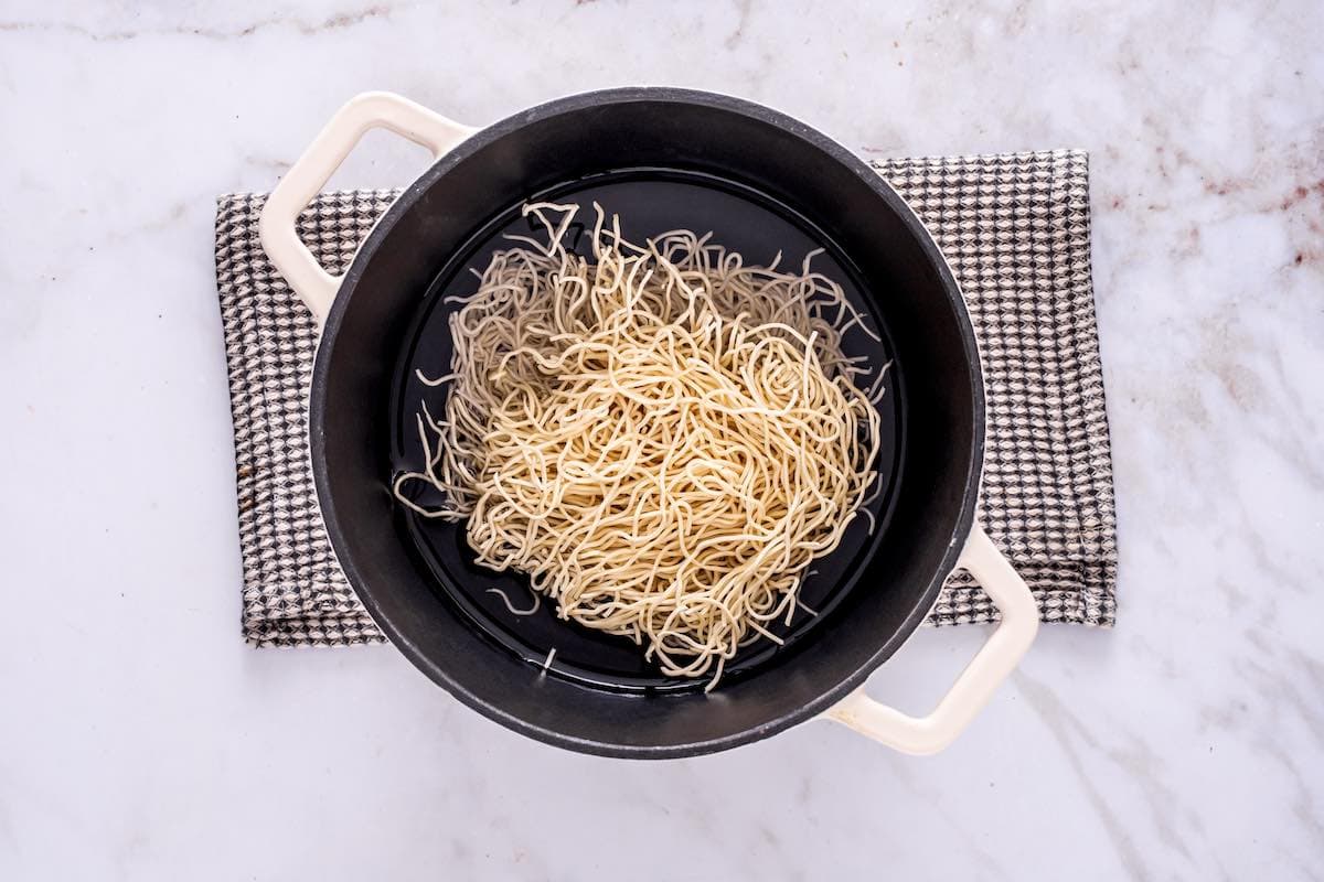 noodles cooking in pot of boiling water.