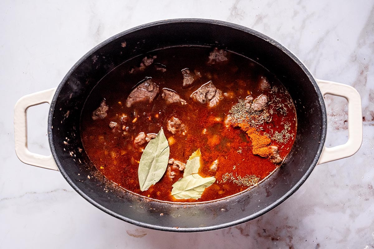 meat, broth, and seasonings in a Dutch oven.