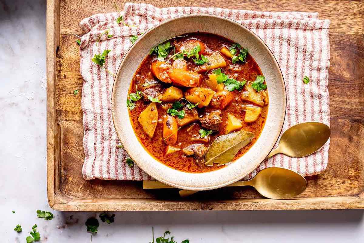 assembled beef stew with herbs on top.