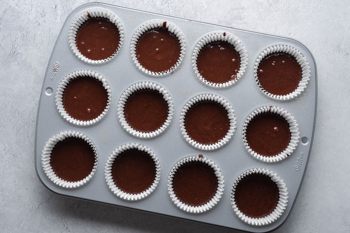 cupcake batter in a lined muffin tray.