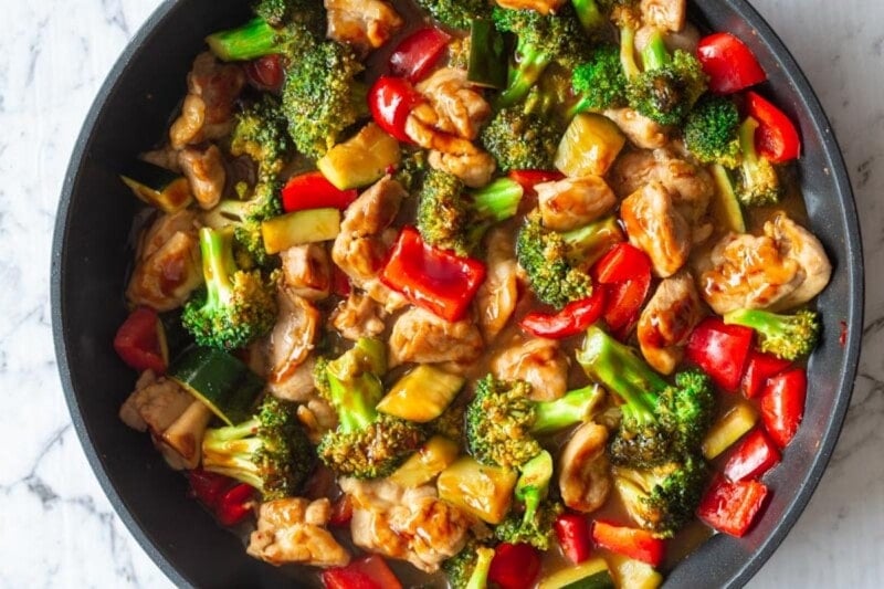 chicken, Hunan sauce, and vegetables in a skillet.