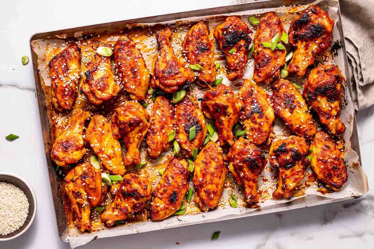 korean chicken wings with chopped green onions on top.