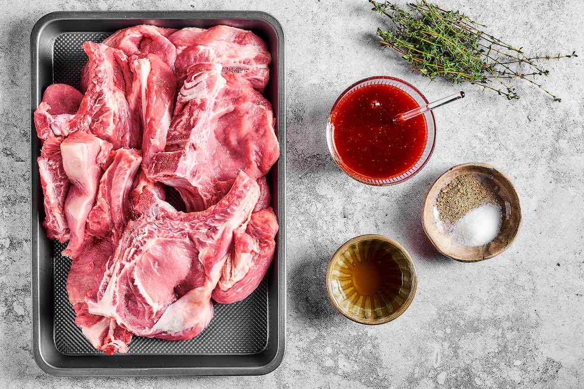 raw ribs on a baking sheet with seasonings.