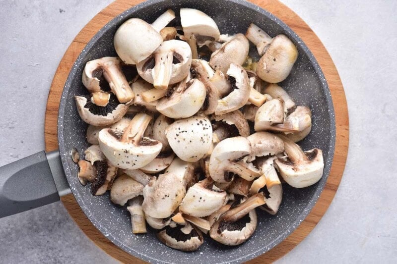 raw mushrooms with butter and oil in a skillet.