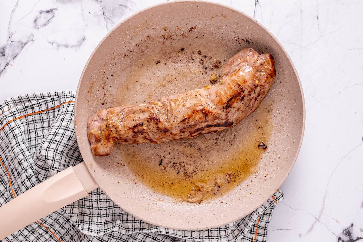 searing the pork tenderloin in a skillet.