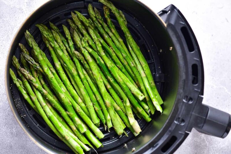 seasoned raw asparagus spears in the air fryer.