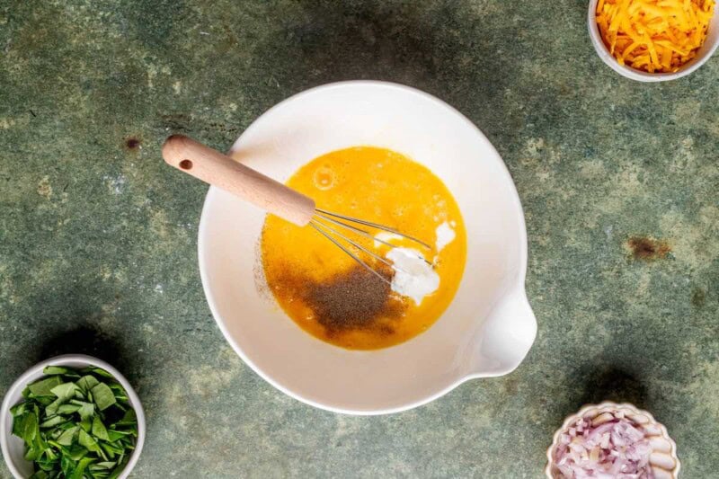 whisked eggs and seasonings in a mixing bowl.