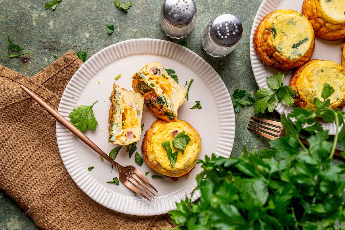 air fryer egg bites on a plate with fresh herbs.