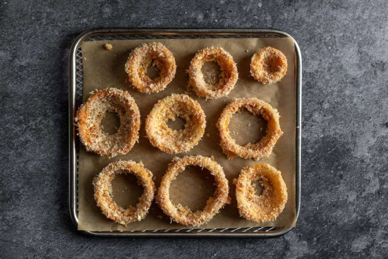 raw breaded onion rings in the air fryer basket.