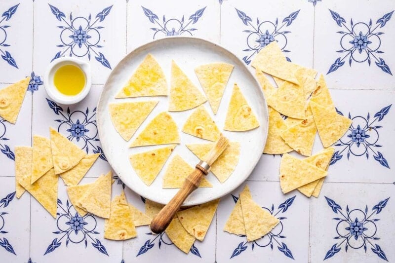 brushing tortillas with oil and seasoning with salt.