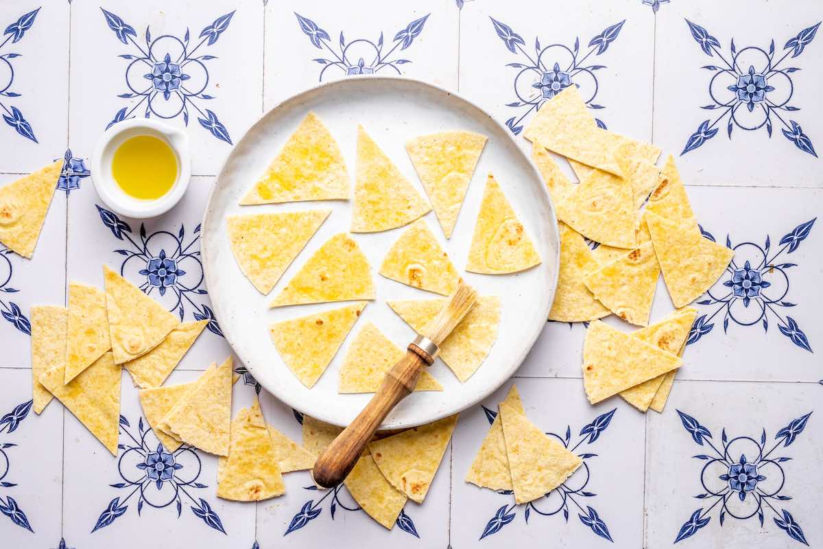 brushing tortillas with oil and seasoning with salt.